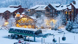 Un albergue cubierto de nieve con varios edificios, telesillas y un asiento de telesilla.