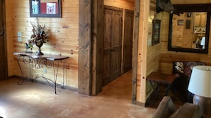 Interior de fusta amb decoració rústica, incloent-hi una taula amb un vas i un mirall penjat a la paret.