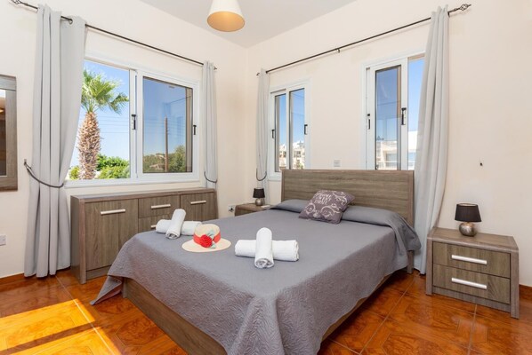 Une chambre d’hôtel avec un grand lit, une tête de lit en bois et deux tables de chevet.