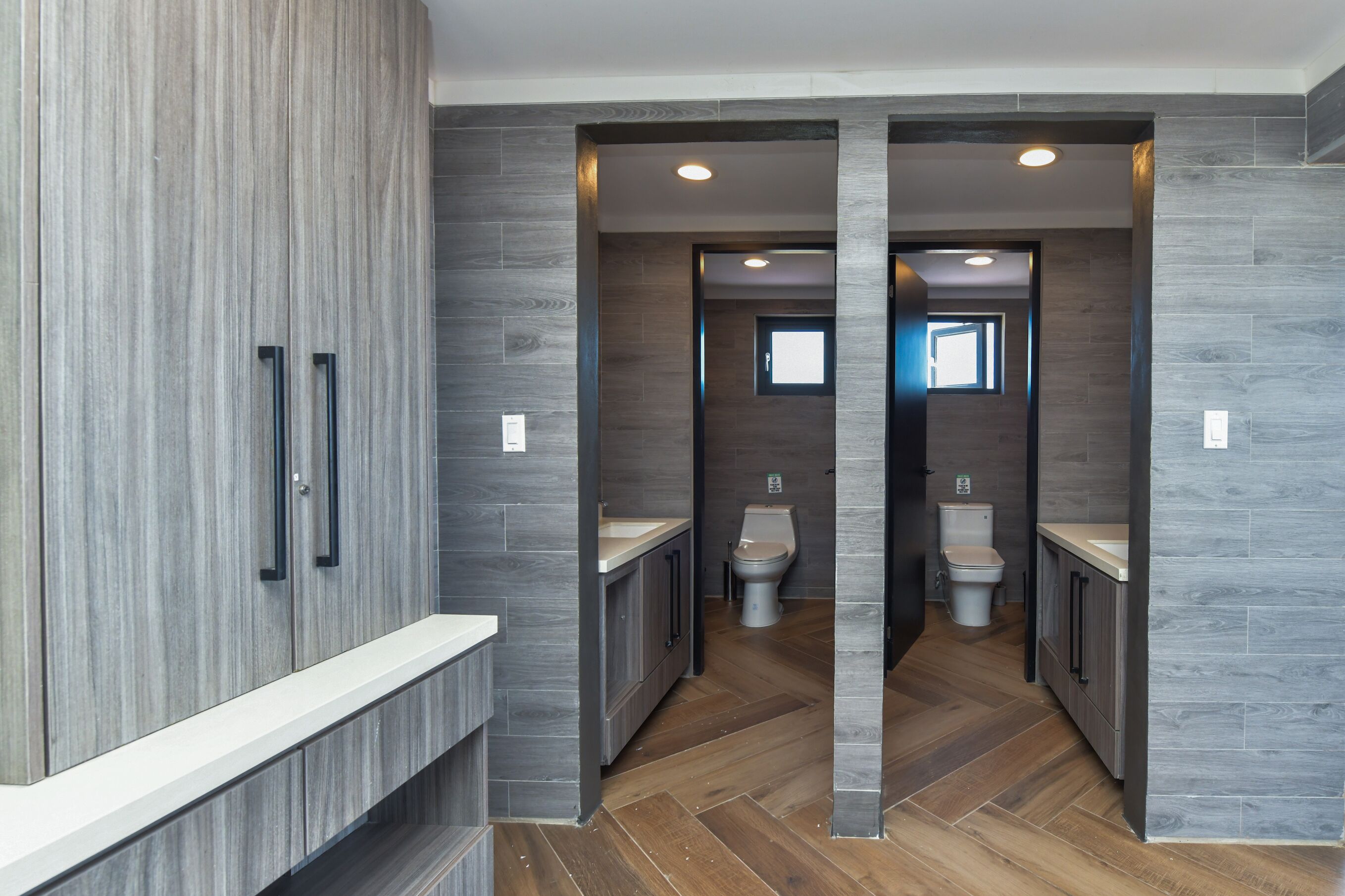 A modern bathroom with a wooden vanity, a toilet, and a sink.