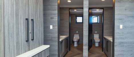 A modern bathroom with a wooden vanity, a toilet, and a sink.