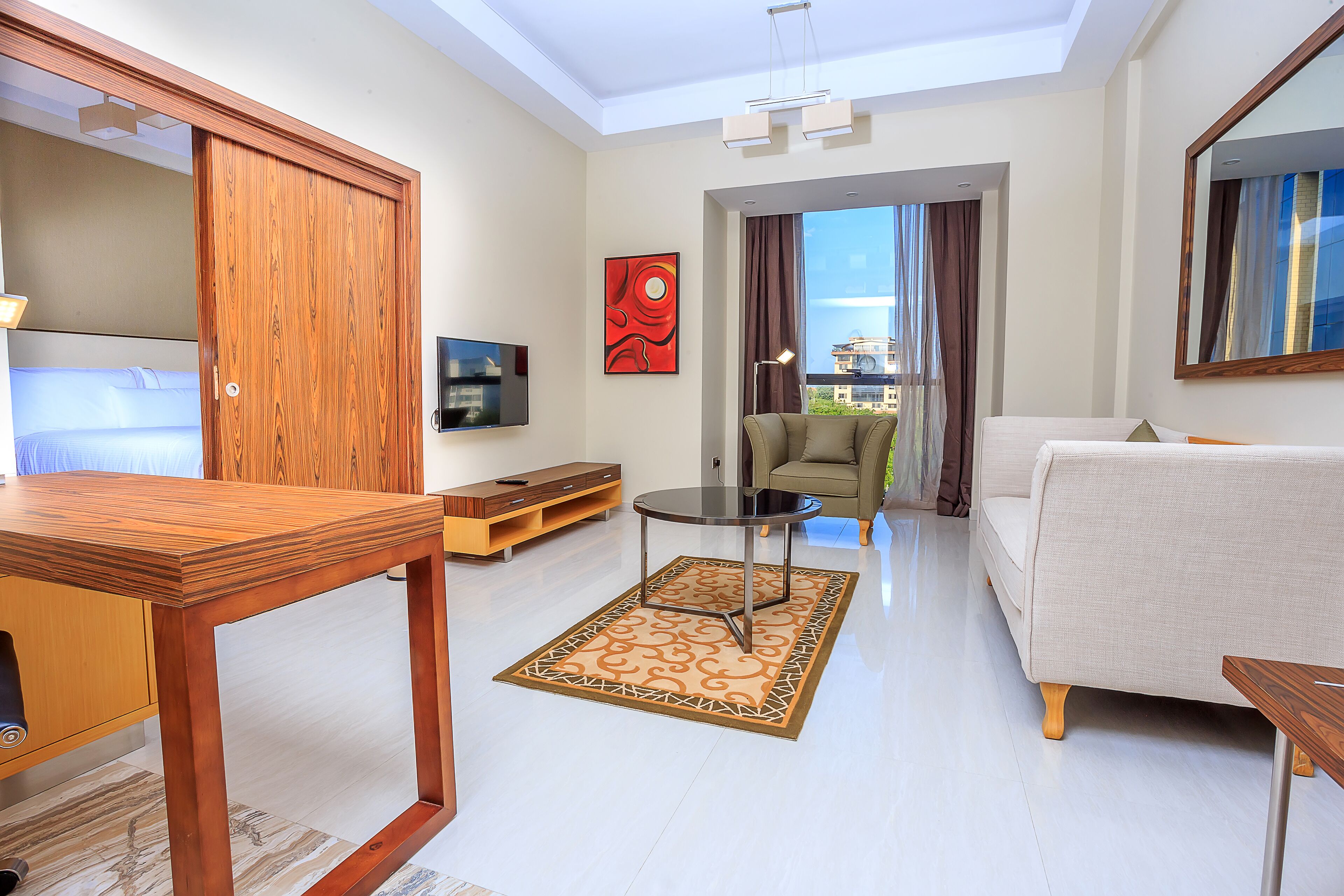 Uma sala de estar moderna com uma mesa de madeira, um sofá e uma varanda com vista.