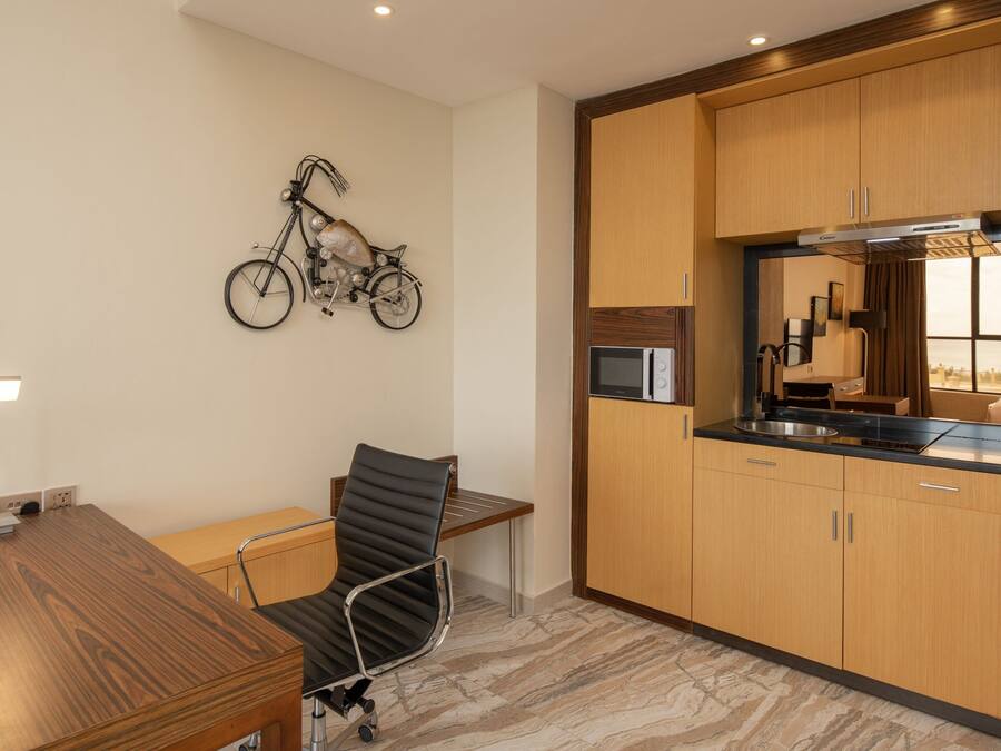 Una cocina moderna con armarios de madera, un microondas integrado y una obra de arte con motivo de bicicleta en la pared.