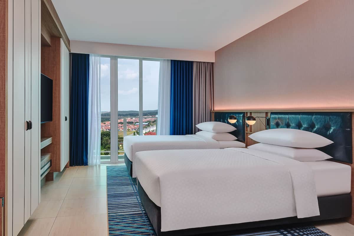 A hotel room with two beds, a large window with a view, and a flat-screen TV.