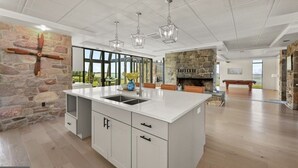 Una cocina amplia con una isla grande, paredes de piedra y vistas al exterior.