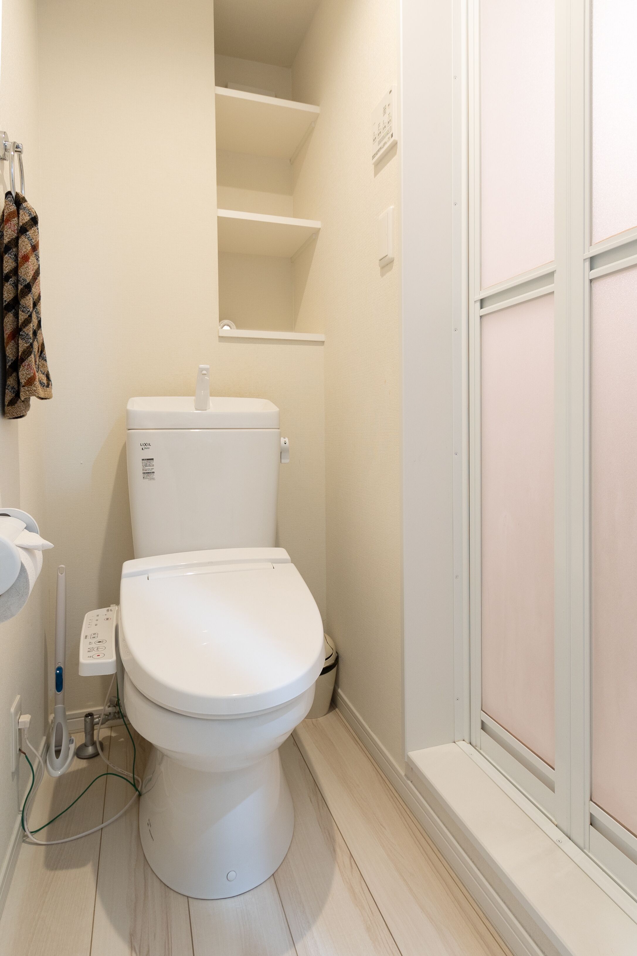 A modern bathroom with a white toilet, a sink, and a shower area.