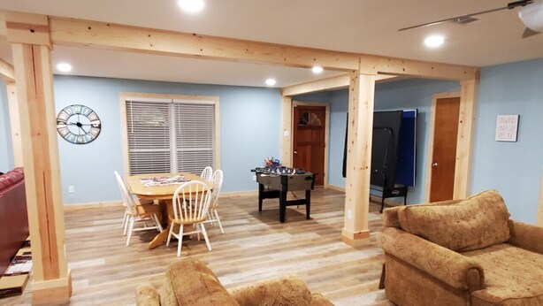 A spacious living room with a wooden floor, a dining area with a table and chairs, and a sofa. - Peaceful Scenic Pond & Home Close to Beach/Sports/Entertainment (Elberta)