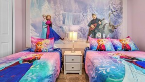 A bedroom with two beds, a nightstand, and a wall mural of animated characters. - 4 Bedrooms / 3 Bathrooms / Storey Lake (4969 WA) (Kissimmee)