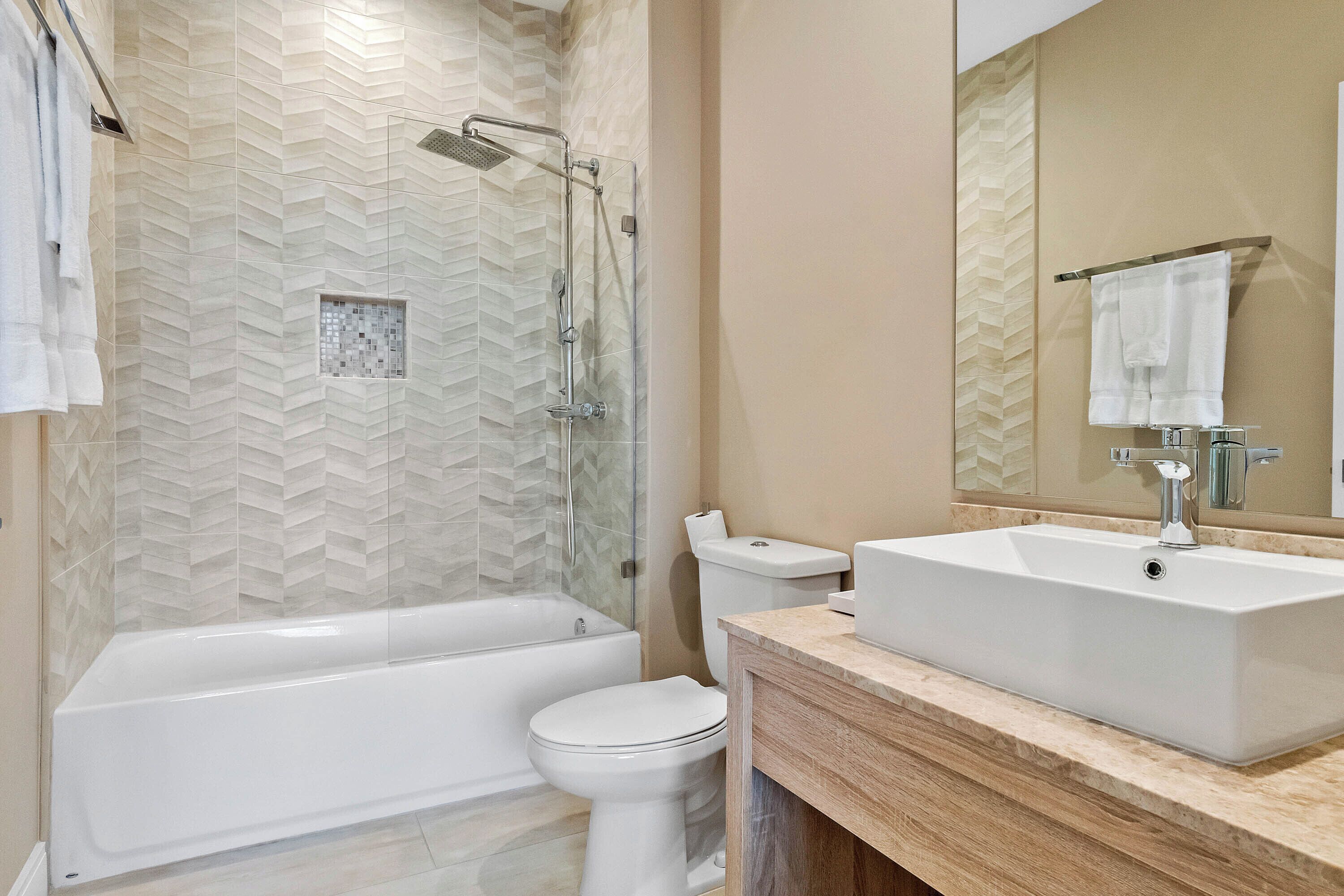 Un baño moderno con bañera, inodoro y lavamanos.