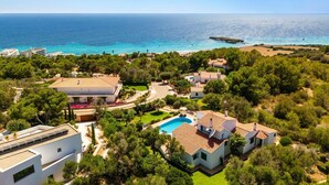 A coastal residential area with houses, a swimming pool, and a view of the sea. - Villa Gecko by Villa Plus (Sant Tomas)