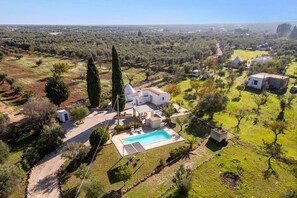 Eine Villa mit Schwimmbad, umgeben von Olivenhainen und freiem Blick auf die Landschaft.