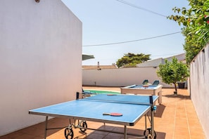 A courtyard with a ping pong table, two lounge chairs, and a small pool. - Villa Quimera by Villa Plus (Cala en Porter)