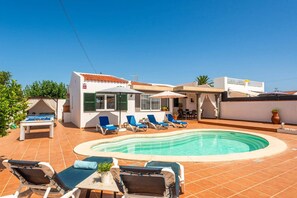 A residential property with a swimming pool, lounge chairs, and a patio area. - Villa Quimera by Villa Plus (Cala en Porter)