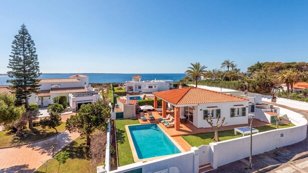 A coastal property with a swimming pool, white buildings, and a view of the sea. - Villa Ondinas by Villa Plus (Ciutadella de Menorca)