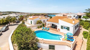 Propiedad residencial con piscina, varias habitaciones y vista al mar.