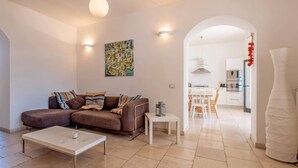 Una sala de estar moderna con un sofá marrón, una mesa de centro blanca y un cuadro en la pared.