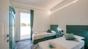 Une chambre d’hôtel avec deux lits, un balcon et une vue sur l’extérieur.