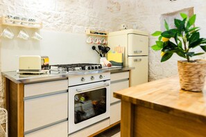 Une cuisine équipée d’une cuisinière, d’un four et de divers ustensiles de cuisine.
