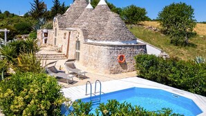 A stone villa with a swimming pool, a covered patio, and a lifebuoy. - Villa Trulli Isabella by Villa Plus (Martina Franca)