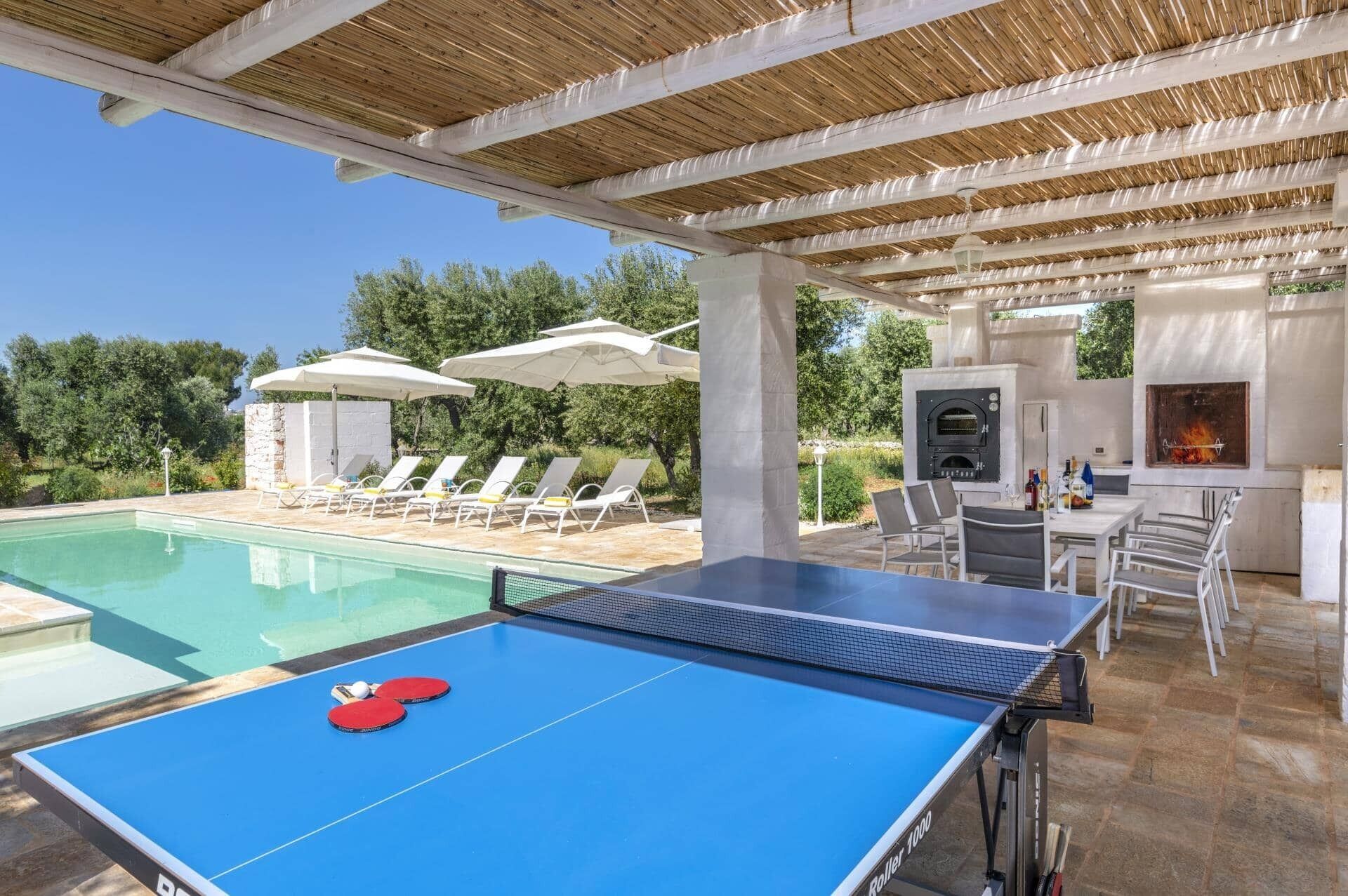 Un tavolo da biliardo, poltrone relax, un'area barbecue e un patio in pietra.