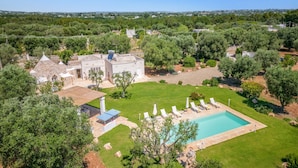 Uma grande moradia com piscina, área de estar ao ar livre e jardim.
