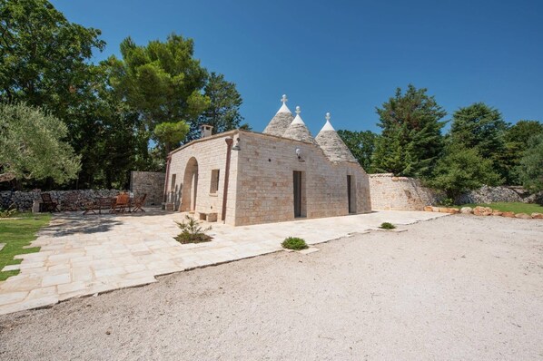A stone building with a courtyard, arched doorways, and a gravel path.