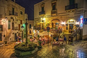 Un bâtiment historique doté d’une terrasse, d’un escalier et d’une enseigne indiquant qu’il s’agit d’un restaurant.