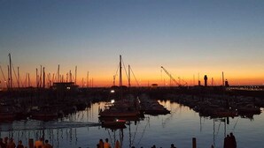 A marina at sunset with numerous boats docked.
