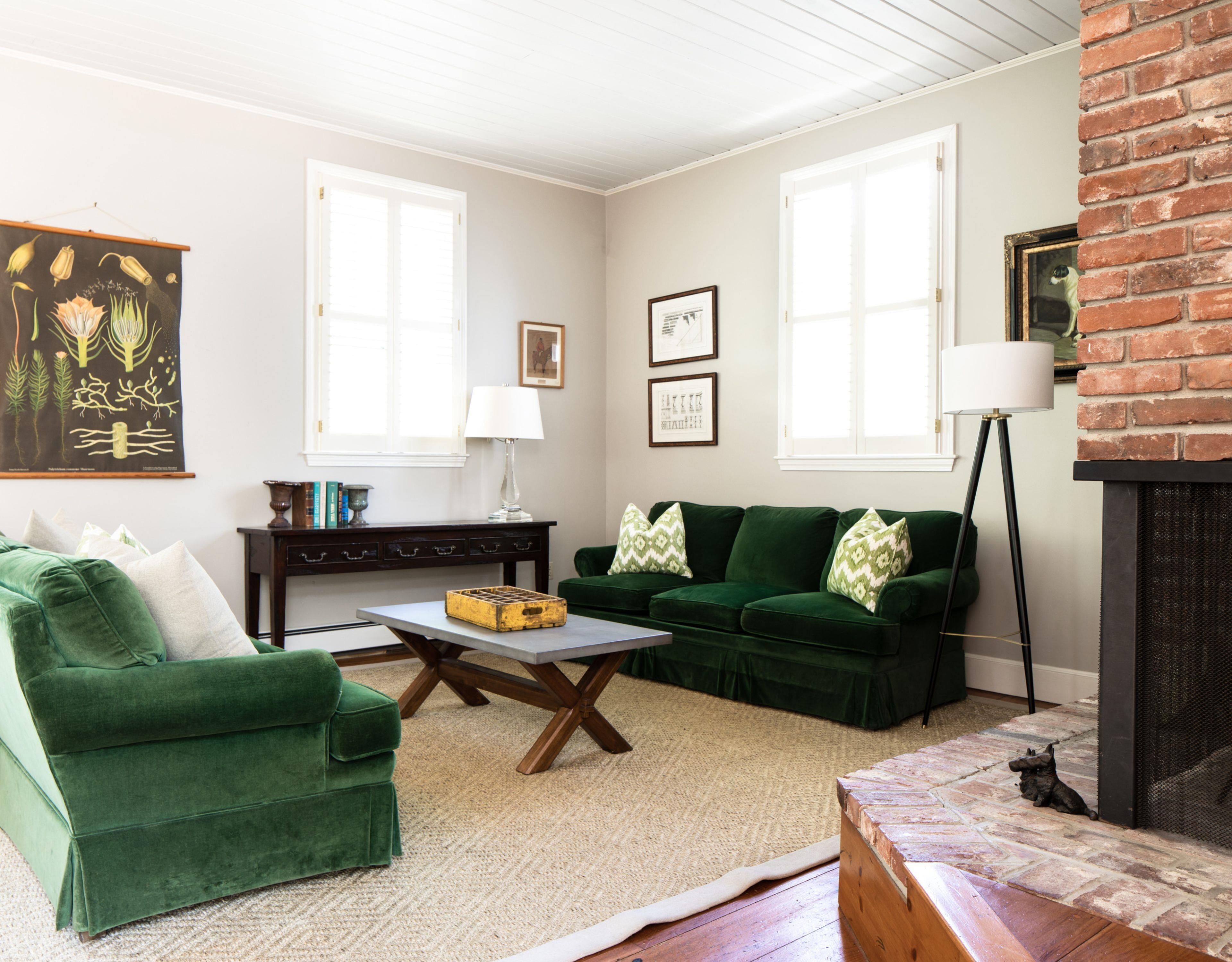 A living room with a green sofa, a coffee table, a fireplace, and a bookshelf.