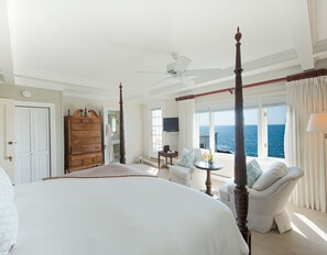 Een hemelbed, een houten dressoir, een televisie en uitzicht op de oceaan.