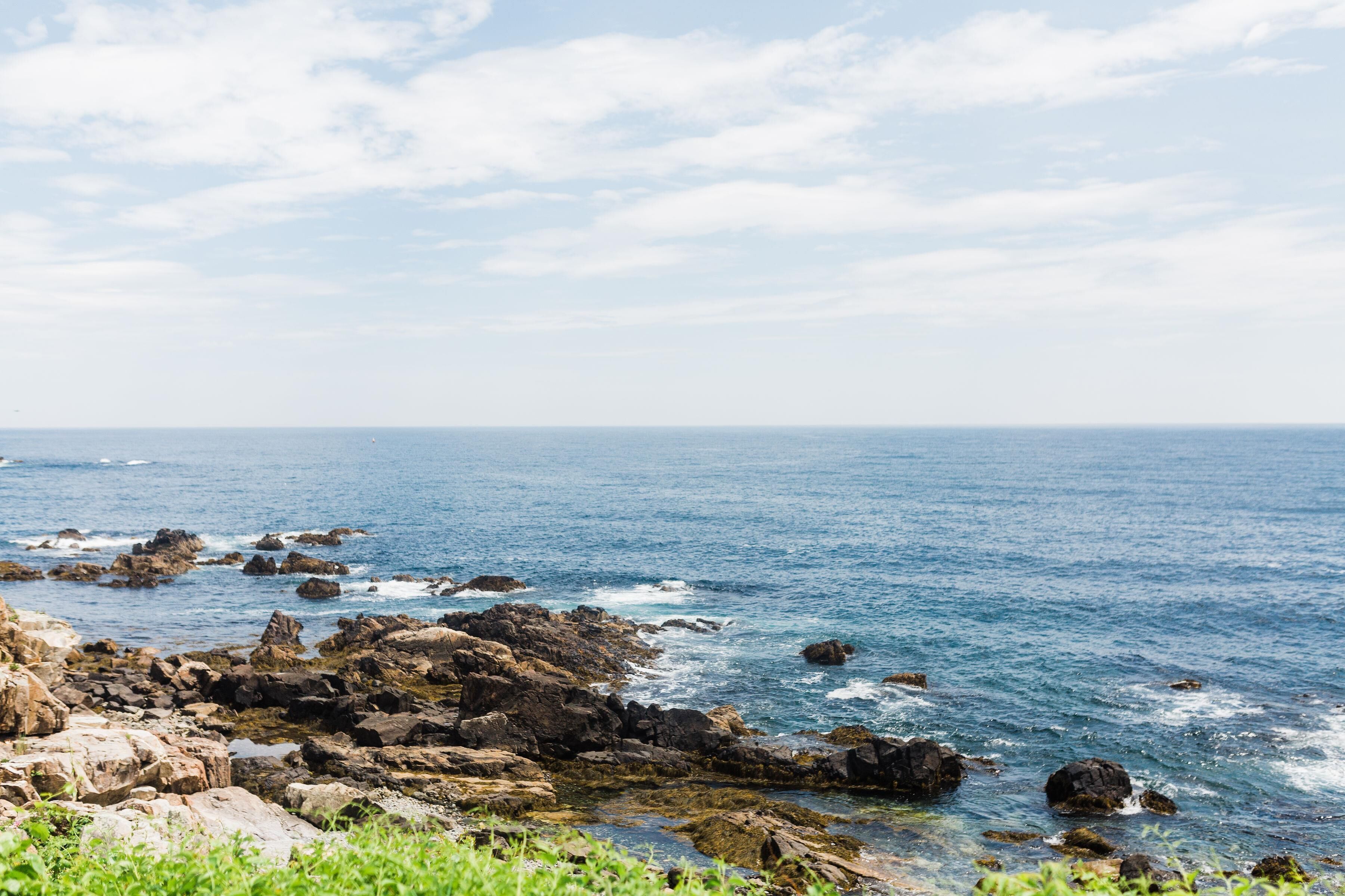 A coastal landscape with rocky terrain and the sea.