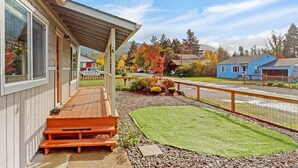 A wooden house with a covered porch, a small lawn, and a gravel path. - Spacious 5BR with Sauna & AC, Fenced Yard,Fast WiFi, Near Willamette Pass (Oakridge)