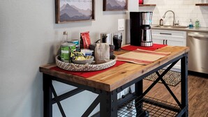 A kitchen with a wooden table, a coffee maker, and a wall-mounted thermostat. - Spacious 5BR with Sauna & AC, Fenced Yard,Fast WiFi, Near Willamette Pass (Oakridge)