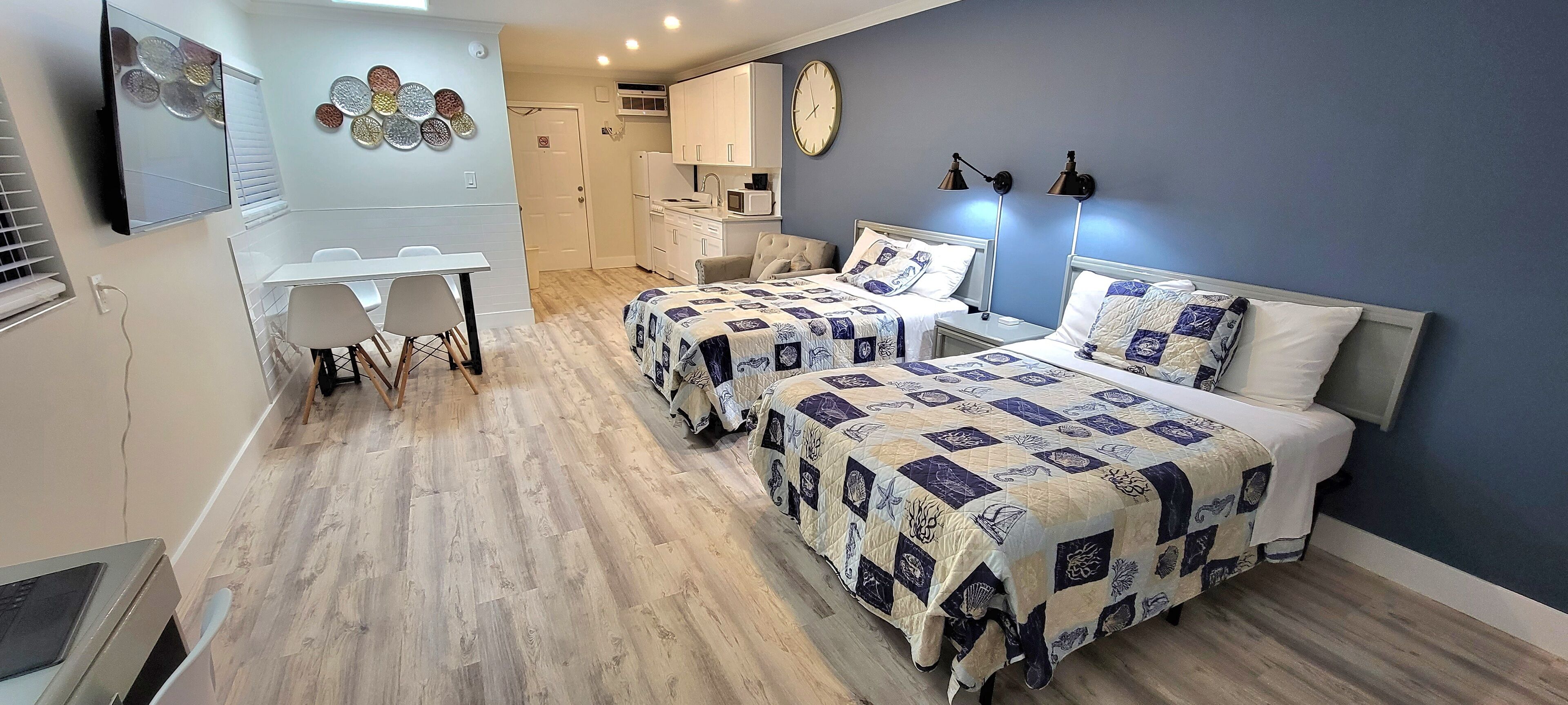 Un dormitorio con dos camas, un escritorio y una silla.