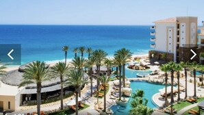 A resort with a pool area, palm trees, and a view of the ocean. - Grand Solmar Land’s End PENTHOUSE - 2 bedroooms + Queen Murphy in Study, 3 Baths (Cabo San Lucas)