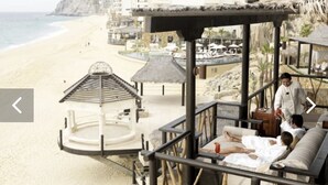 A beachside resort with a pool, lounge area, and thatched-roof structures. - Grand Solmar Land’s End PENTHOUSE - 2 bedroooms + Queen Murphy in Study, 3 Baths (Cabo San Lucas)