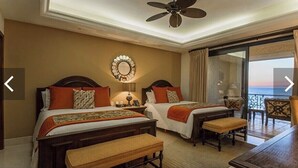 A hotel room with two beds, a ceiling fan, a view of the sea, and a balcony with a table and chairs. - Grand Solmar Land’s End PENTHOUSE - 2 bedroooms + Queen Murphy in Study, 3 Baths (Cabo San Lucas)