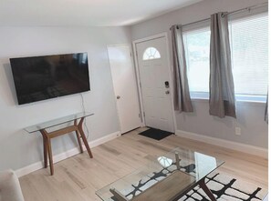 Relax in this stylish living room with a flat-screen TV, glass coffee table, and comfortable seating area.