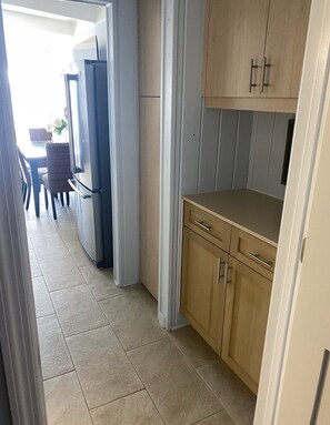 A kitchen with light wood cabinets, a countertop, and a tiled floor.