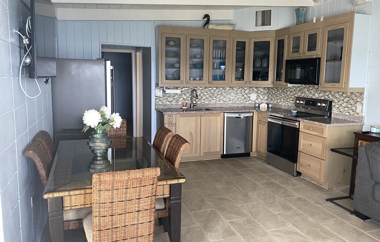A kitchen with wooden cabinets, a built-in microwave, and a dishwasher.