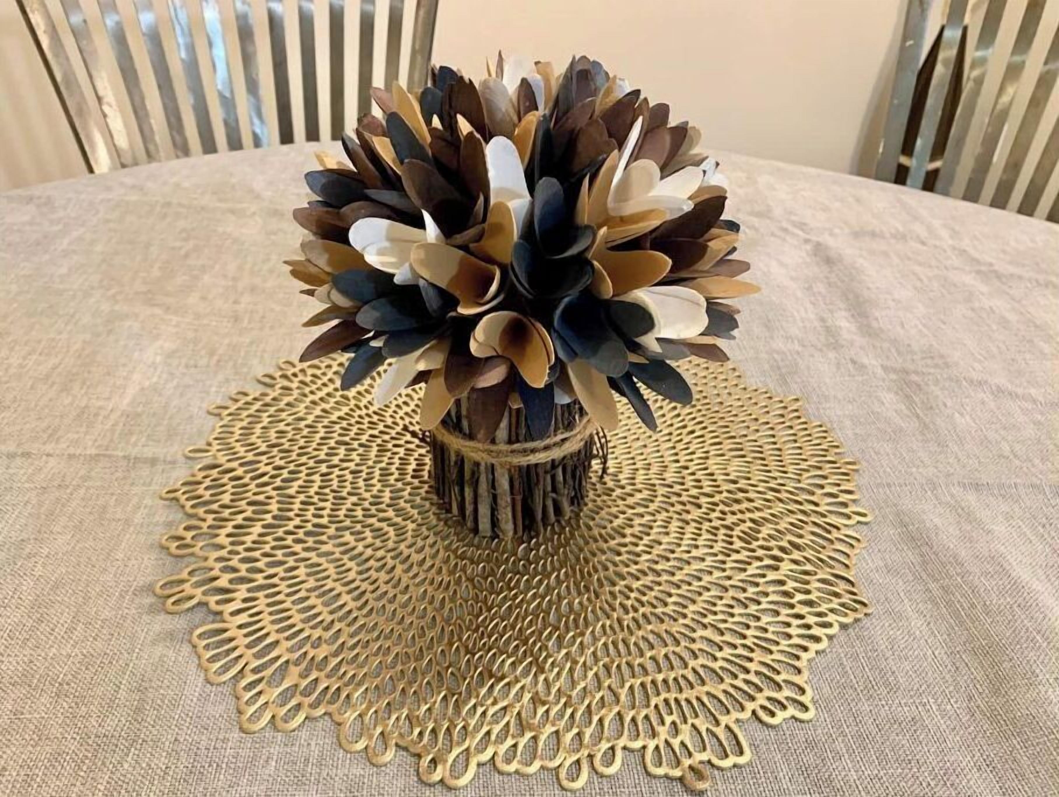 A table with a decorative centerpiece consisting of a woven doily and a vase with a floral arrangement.