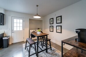 Kitchen area with central island, sink, and dining table for four.