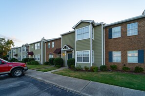 Townhouses with brick facades and varied siding colors line the street.