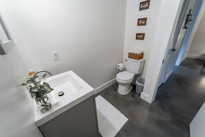 Bathroom features a sink, toilet, and storage for essentials.