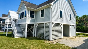 A two-story house with a covered garage and a staircase leading to the upper level. - Beach Breezes - Oceanside, 4 bedrooms (Pawleys Island)