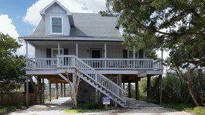 Une maison à deux étages dotée d’un porche abrité et d’un escalier menant à l’étage supérieur.