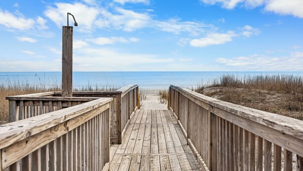 A wooden boardwalk leading to a beach with a metal lamp post. - Allston - 4 bedrooms, Oceanfront (Pawleys Island)