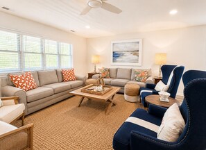 A living room with a sofa, armchairs, a coffee table, and a painting on the wall. - Katinka II - Oceanside, 4 bedrooms (Pawleys Island)