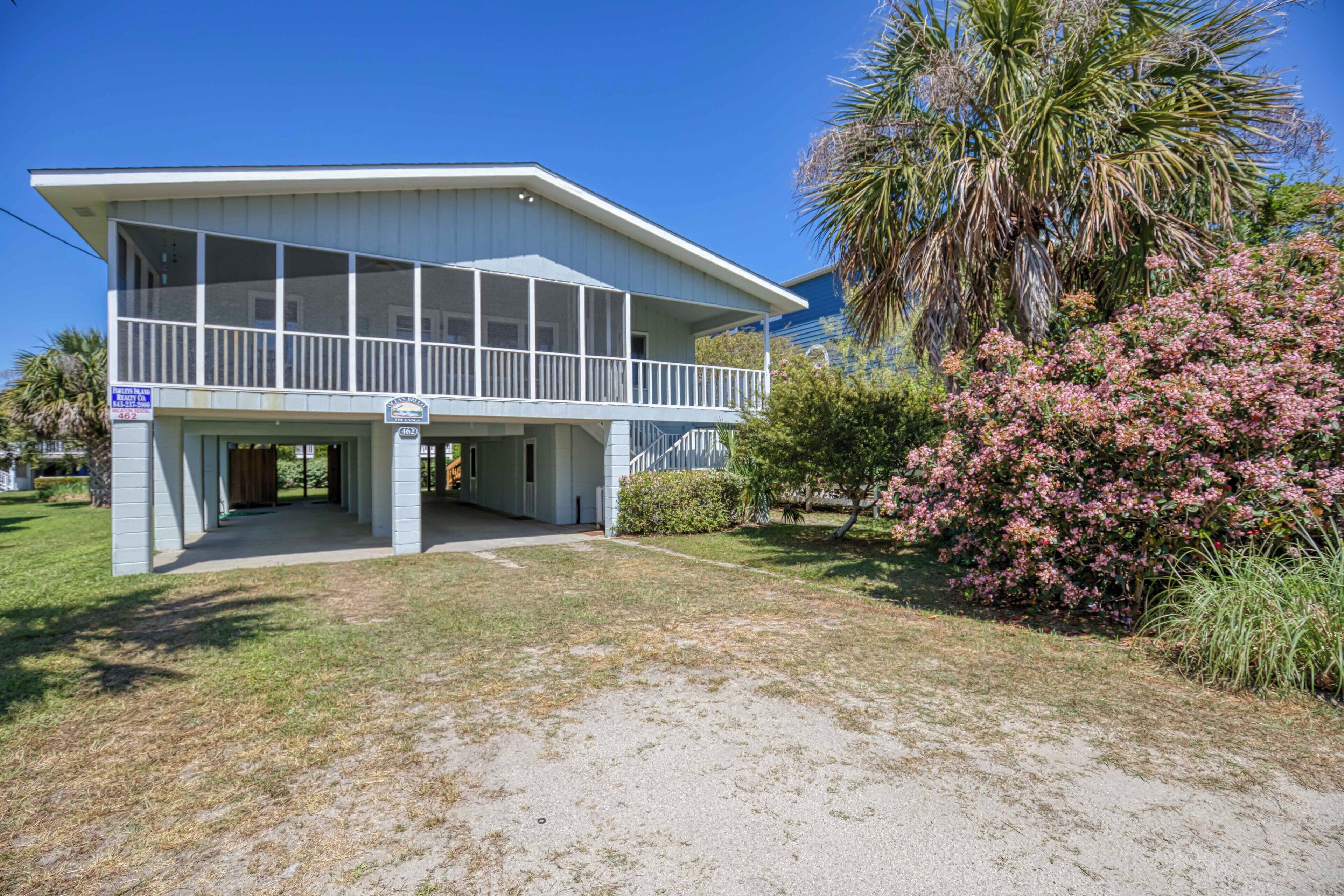 A two-story building with a balcony, a covered entrance, and a well-maintained lawn.