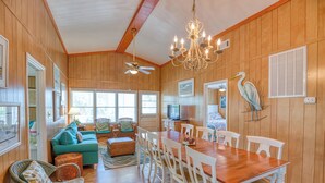 A spacious room with a wooden floor, a dining table with chairs, a ceiling fan, and a chandelier. - Ocean Breeze - Near Ocean, 5 Bedrooms, Litchfield (Litchfield)